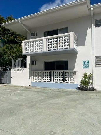 Front view of a two-story building with decorative railings and a flat roof.