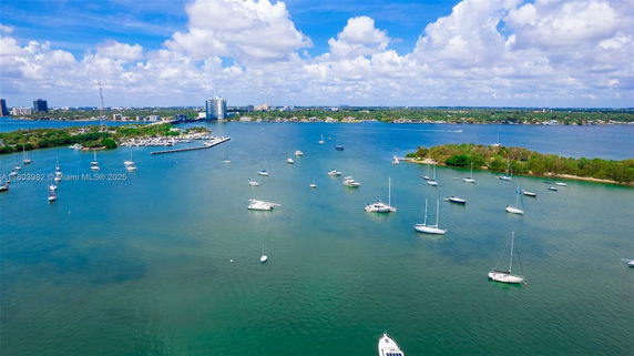 Panoramic view of a waterbody with boats and distant cityscape.