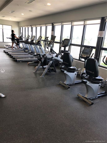 Interior view of a gym area with treadmills and exercise bikes.