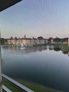 View of apartment buildings reflected in a body of water.
