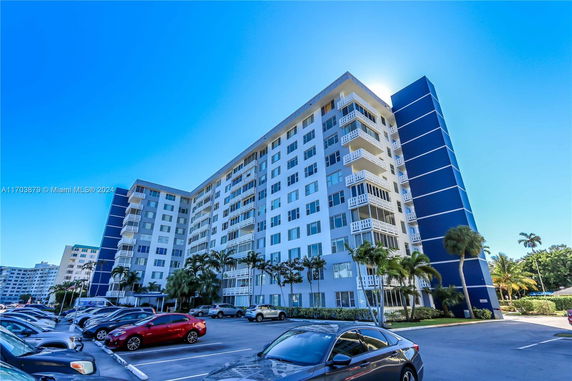 Front view of a multi-story residential building with balconies and a blue accent facade.