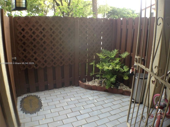 Enclosed outdoor area with wooden fence and patio floor.