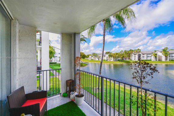 Balcony view overlooking a pond and residential buildings.