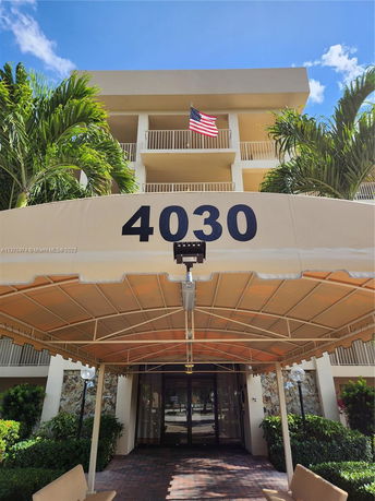 Front view of a building with a canopy entrance and an American flag.