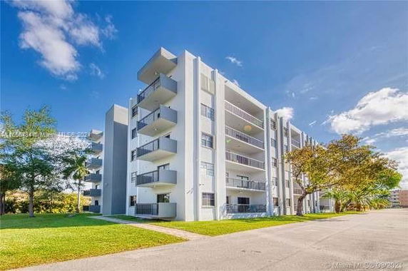 Front view of a multi-story apartment building with balconies.