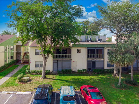 Front view of a two-story building with parking area in front.