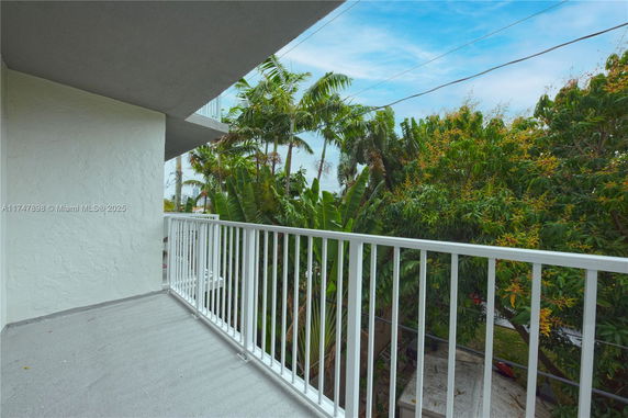 Balcony with a view of surrounding greenery and trees.