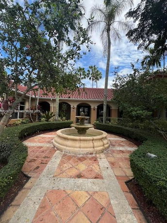 View of the entrance garden with a fountain in front of a house.