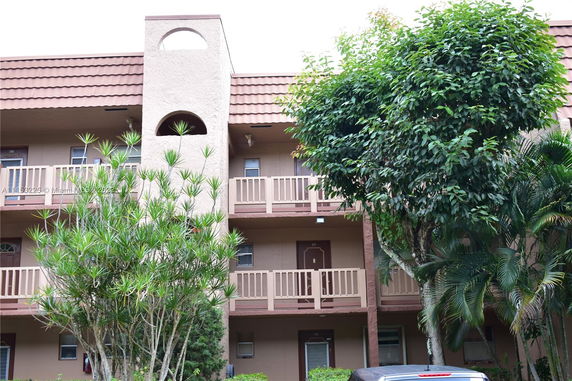 Front view of a multi-story building with balconies and textured facade.