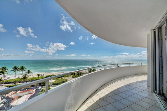 Panoramic view from a building balcony overlooking the ocean.