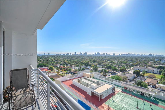 Panoramic view from a balcony overlooking a cityscape under a clear blue sky.