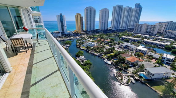 Aerial view of coastal cityscape with high-rise buildings and waterways.