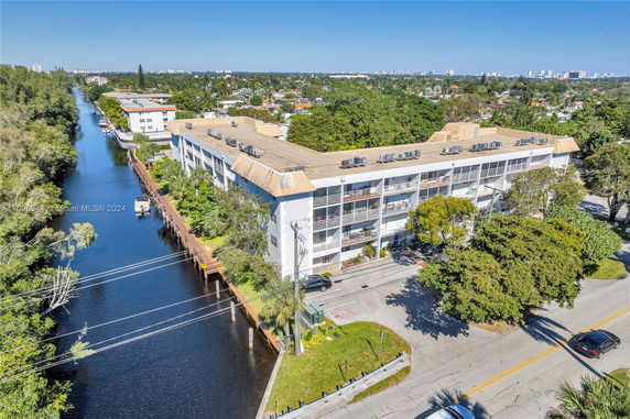 Aerial view of a multi-story building with a canal running alongside it.