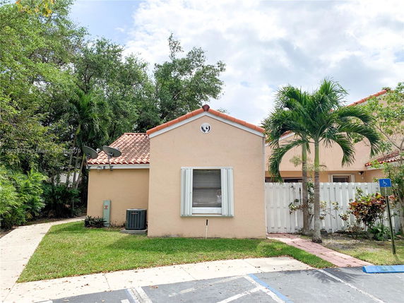 Front view of a single-story house with a tile roof and satellite dishes.