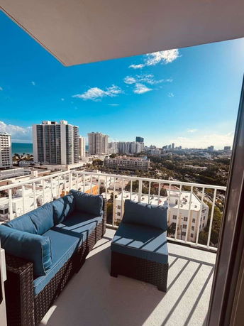 View from a high-rise balcony overlooking a cityscape with numerous tall buildings.