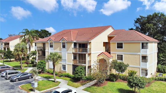 Front view of a multi-story apartment building with red-tiled roof.