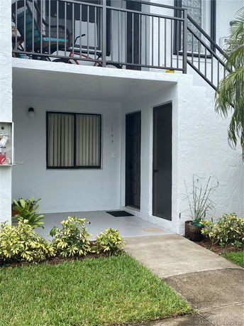 Front view of a two-story residential building with a small porch area.