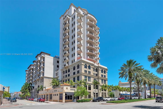 Front view of a tall multi-story building with balconies and arched windows.