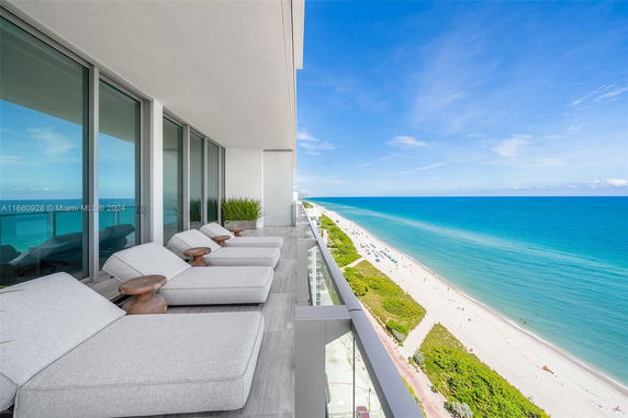 Panoramic view from a balcony overlooking a beach and ocean.