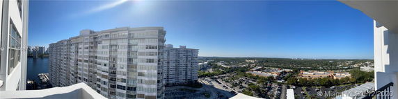 Panoramic view of high-rise buildings with a water body and urban landscape in the background.