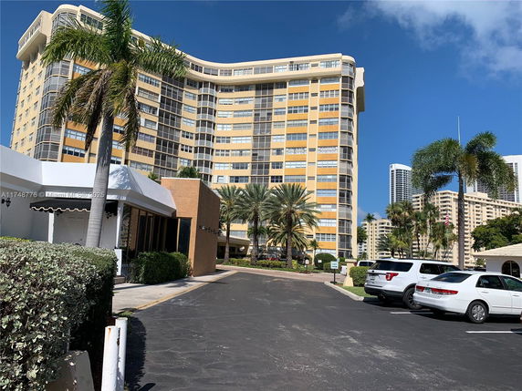 Front view of a large residential building with multiple floors and balconies.