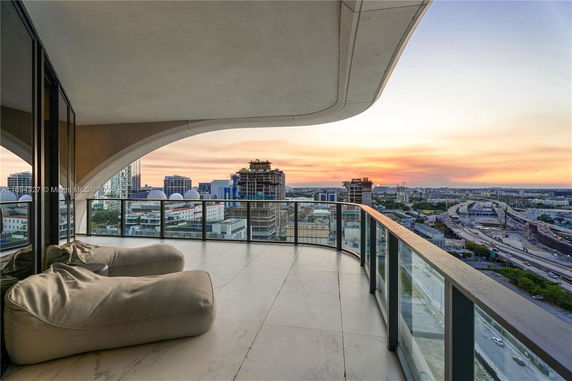 Balcony view overlooking cityscape at sunset.