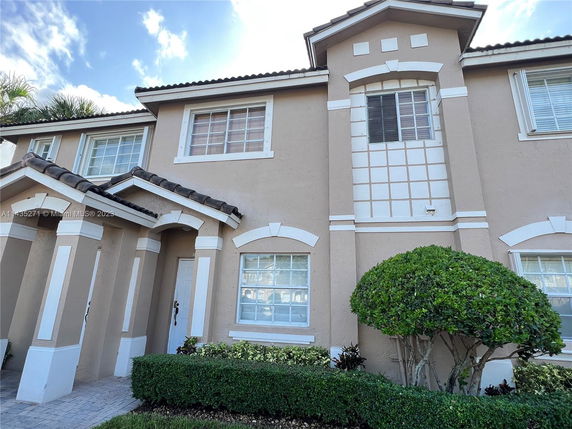 Front view of a two-story house with decorative window frames and a tiled roof.