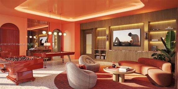 Recreation area with modern decor, featuring a foosball table and stylish seating.