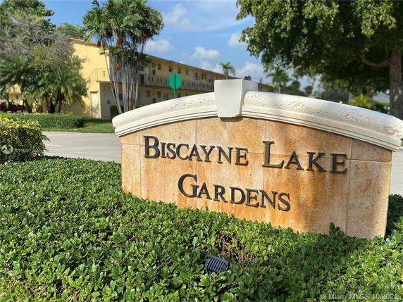 Front view of a multi-story building with a sign reading 'Biscayne Lake Gardens.'