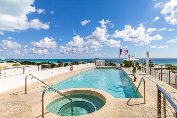Rooftop swimming pool with ocean view and American flag.
