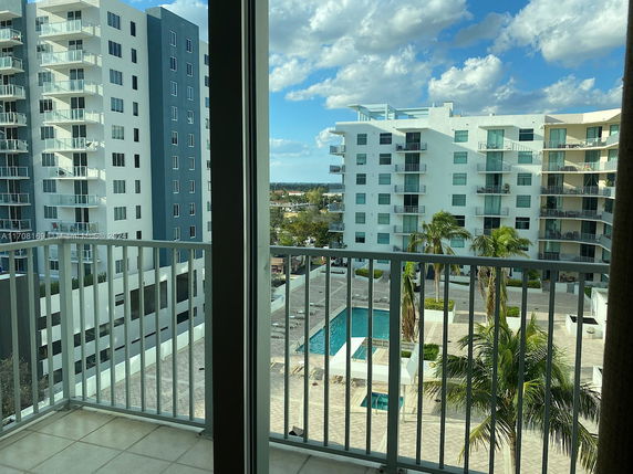 View from a balcony overlooking multi-story residential buildings with balconies.