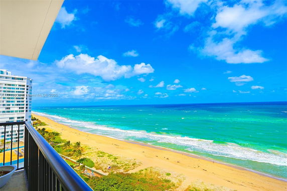 Panoramic view of a coastline and ocean from a building balcony.