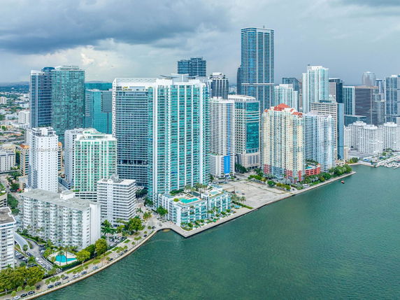 Aerial view of multiple high-rise buildings along a waterfront in a city.