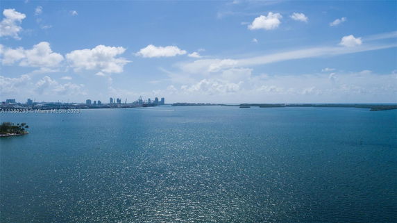 Wide angle view of a large body of water with city skyline in the distance.
