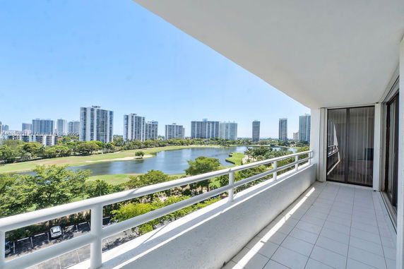 View from a balcony overlooking a cityscape with high-rise buildings and a lake.