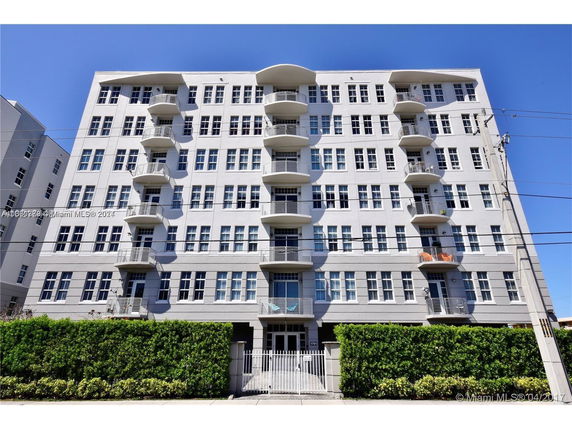 Front view of a multi-story apartment building with multiple balconies.