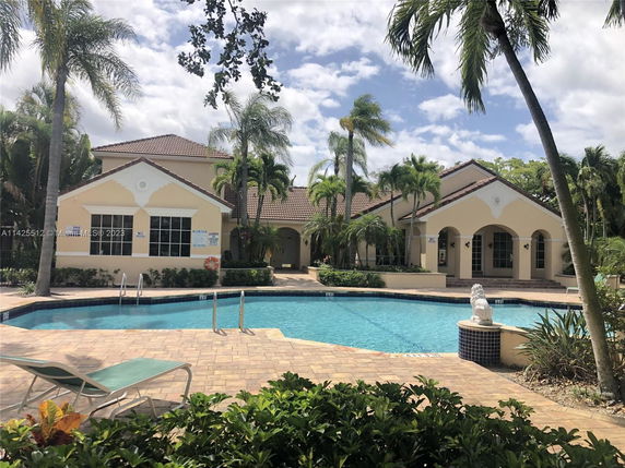 View of a house with a swimming pool in front.