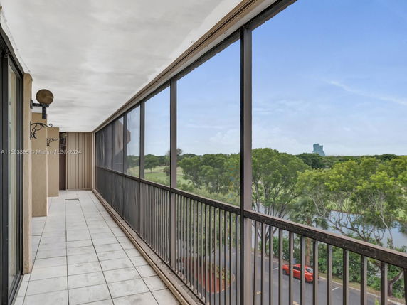 Outdoor balcony view with surrounding landscape and distant tower.