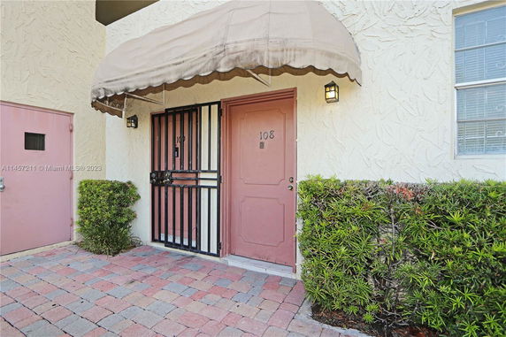 Front view of a building entrance with a canopy and a security door.