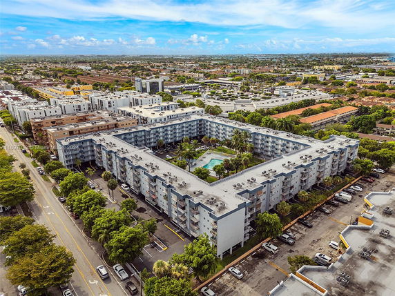 Aerial view of a large residential building complex with a central courtyard and swimming pool.