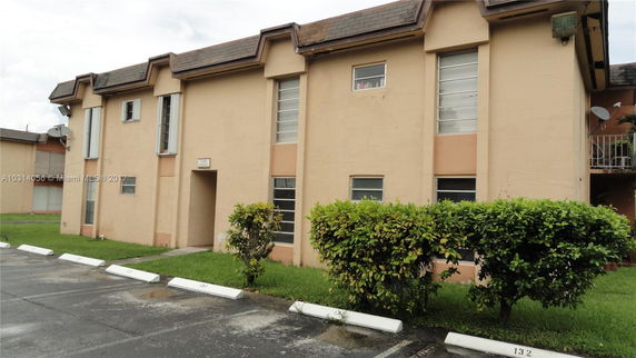 Front view of a two-story building with parking spaces.