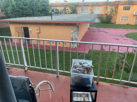 View from a balcony overlooking a building and grassy area.