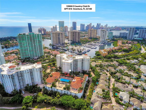 Aerial view of a coastal cityscape with high-rise buildings and waterways.
