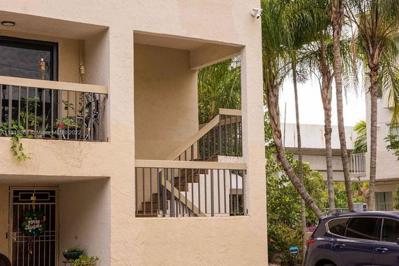 Front view of a two-story residential building with an exterior stairway.
