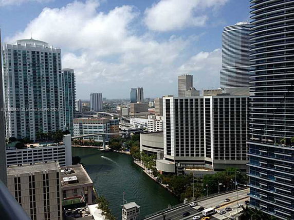 View of a cityscape with tall buildings and a waterway running through the area.