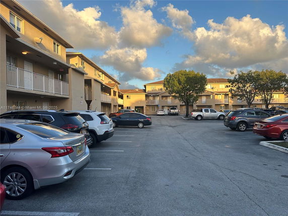 Outdoor parking area in front of a multi-story apartment building.