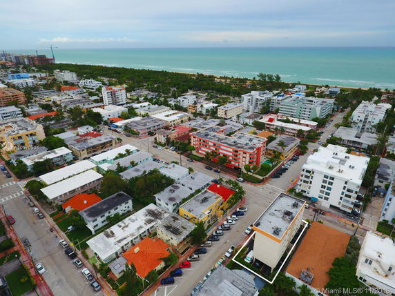 Panoramic view of a coastal residential area with multiple buildings and the ocean in the background.