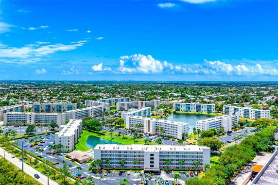 Panoramic view of a residential complex with several multi-story buildings and green areas around them.