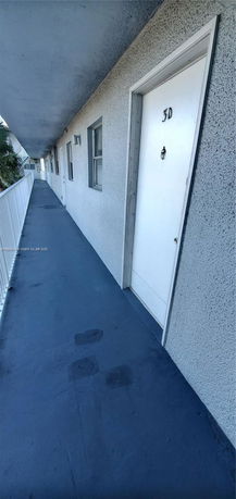 View of a corridor with multiple doors in an exterior hallway.