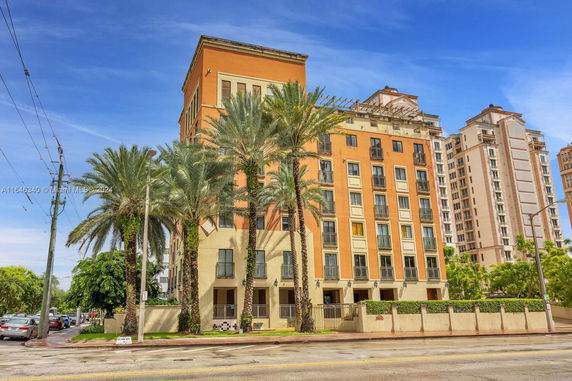 Front view of a multi-story building with palm trees.